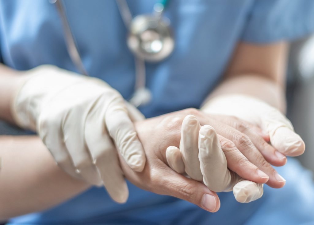 RN holding a patients' hands